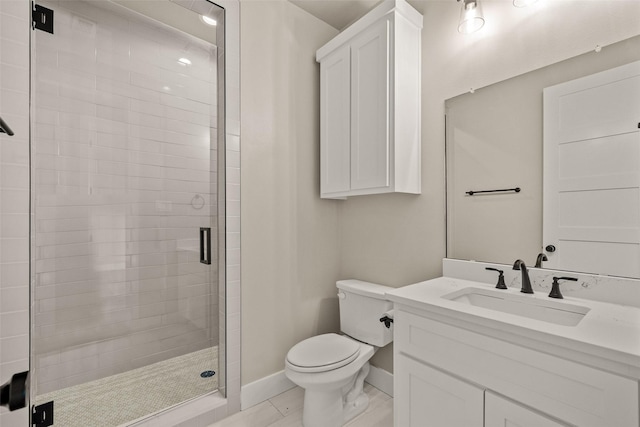 bathroom featuring tile patterned floors, vanity, toilet, and a shower with shower door