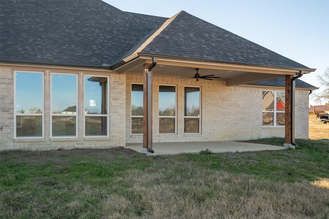 back of property featuring ceiling fan, a patio area, and a lawn