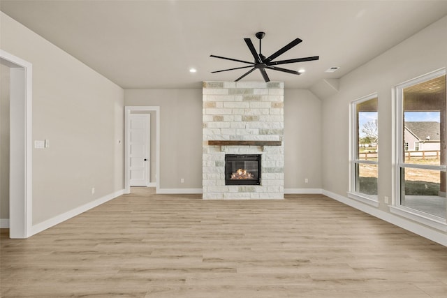 unfurnished living room with ceiling fan, a fireplace, and light hardwood / wood-style floors