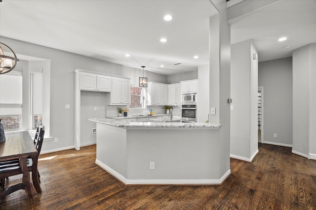 kitchen with light stone countertops, stainless steel appliances, dark hardwood / wood-style flooring, decorative backsplash, and white cabinets