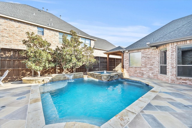 view of pool with a patio area, pool water feature, and an in ground hot tub