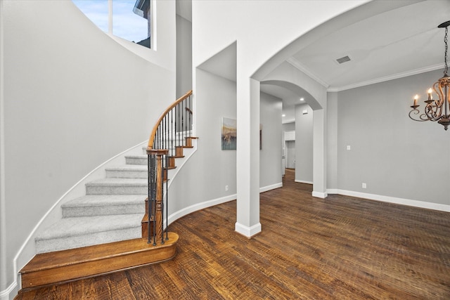 interior space featuring hardwood / wood-style floors, ornamental molding, and an inviting chandelier