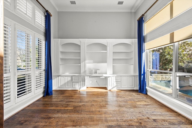 unfurnished room featuring built in shelves, wood-type flooring, and ornamental molding