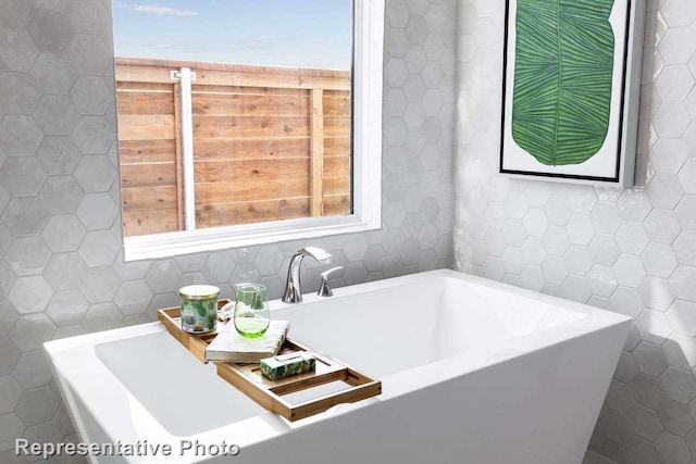 bathroom with a bath and tile walls