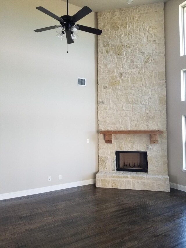 unfurnished living room with ceiling fan, plenty of natural light, wood-type flooring, and a fireplace