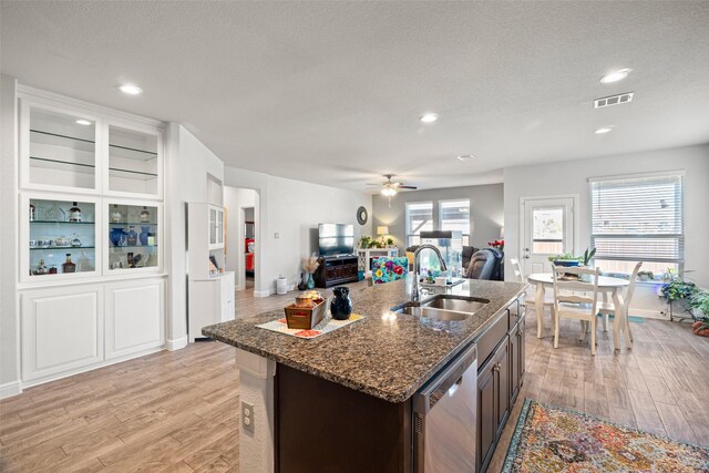 kitchen featuring dishwasher, dark brown cabinetry, sink, and light hardwood / wood-style flooring