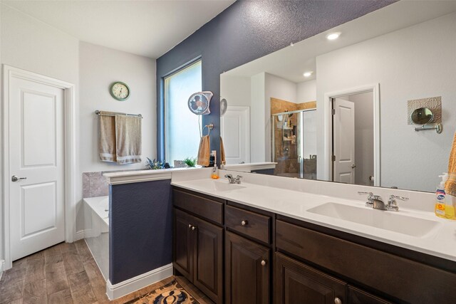 bathroom with vanity and shower with separate bathtub