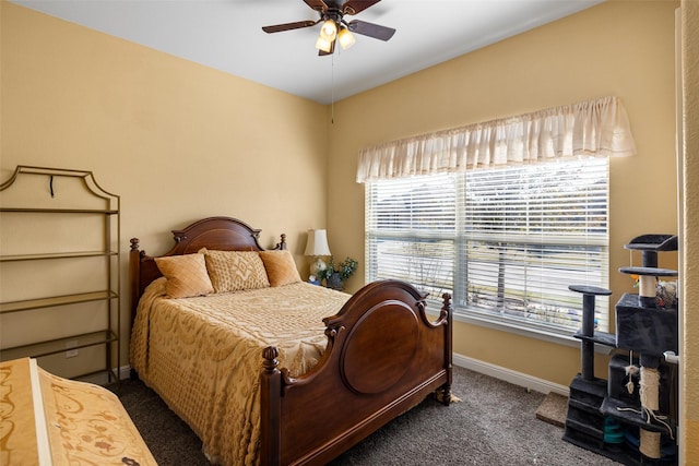 bedroom with ceiling fan, dark carpet, and multiple windows