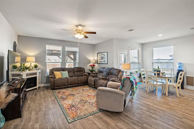 living room with hardwood / wood-style floors, ceiling fan, and a wealth of natural light