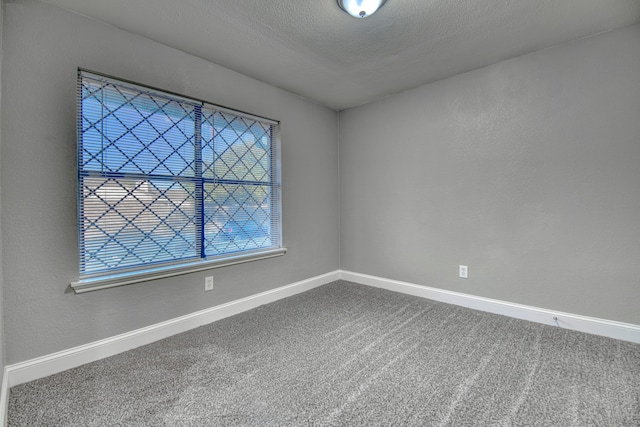 carpeted spare room featuring a textured ceiling