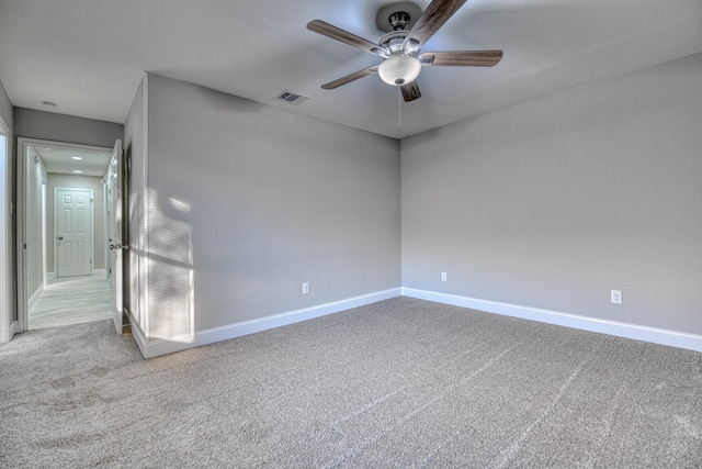 spare room with ceiling fan and carpet