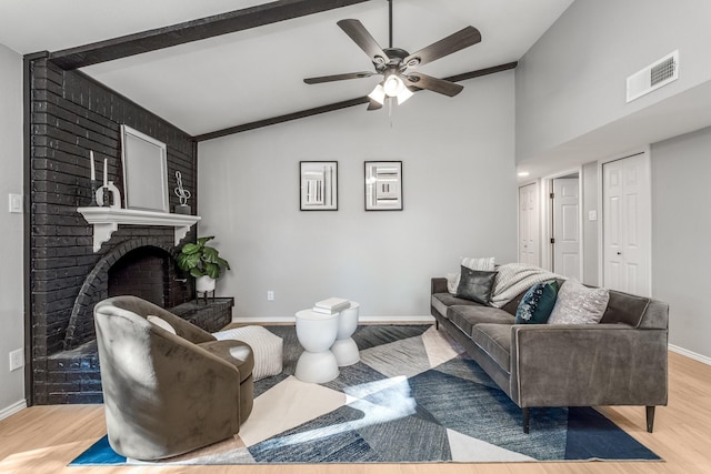 living room with lofted ceiling with beams, a fireplace, ceiling fan, and light hardwood / wood-style floors