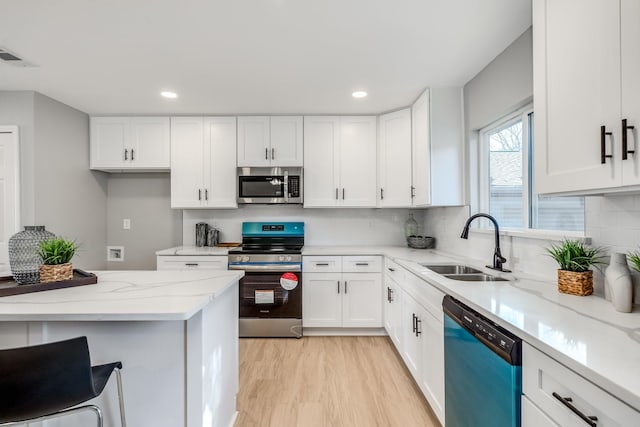 kitchen featuring white cabinets, light stone counters, sink, and stainless steel appliances