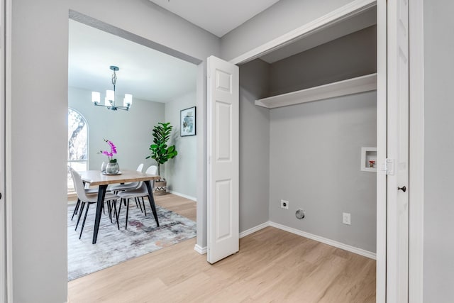 laundry room featuring washer hookup, hardwood / wood-style floors, and a notable chandelier