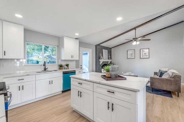 kitchen featuring backsplash, dishwashing machine, vaulted ceiling, sink, and white cabinetry