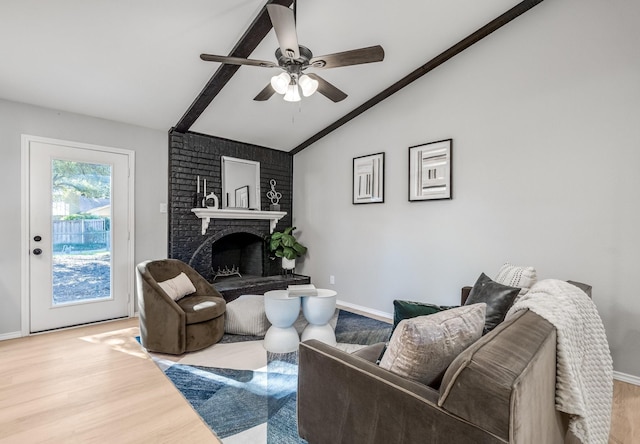 living room featuring ceiling fan, a fireplace, vaulted ceiling, and light wood-type flooring