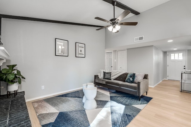 living room featuring hardwood / wood-style floors, vaulted ceiling with beams, and ceiling fan