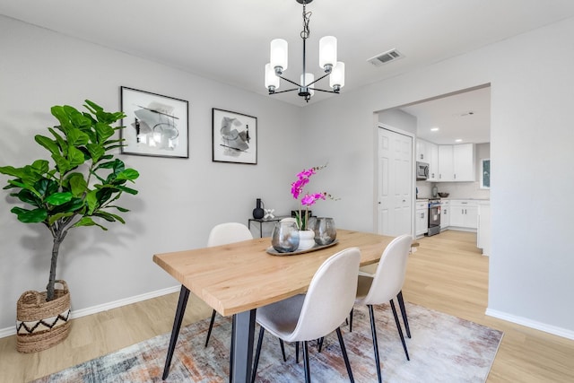 dining area featuring a chandelier and light hardwood / wood-style floors