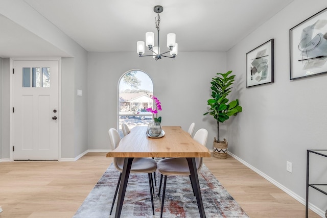 dining area with an inviting chandelier and light wood-type flooring