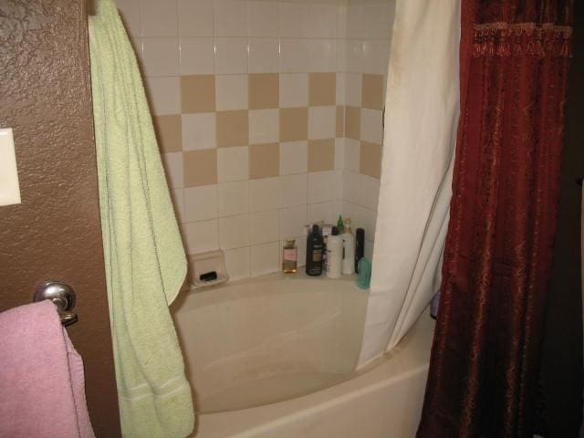 bathroom with shower / bath combo with shower curtain