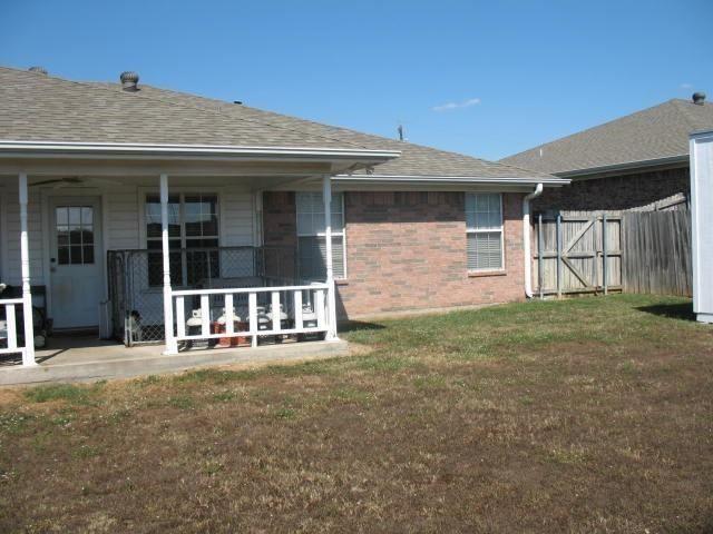 rear view of property featuring a lawn and a patio area