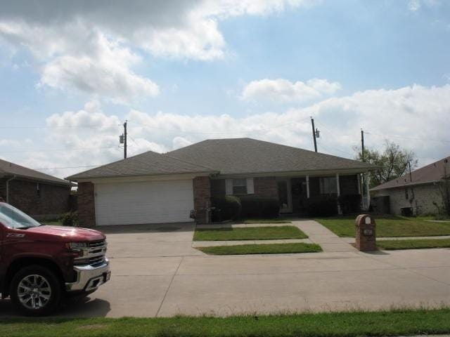 ranch-style home with a garage and a front lawn