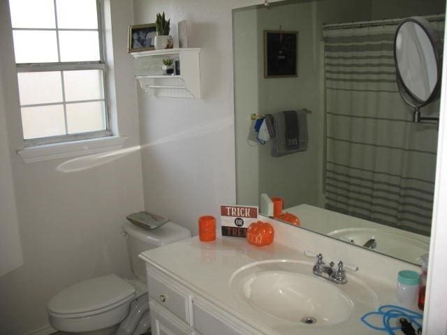 bathroom featuring vanity, toilet, and walk in shower