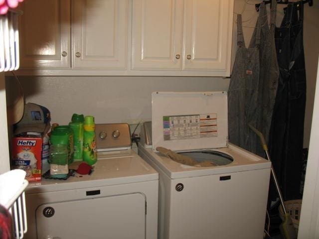 washroom with cabinets and washing machine and dryer