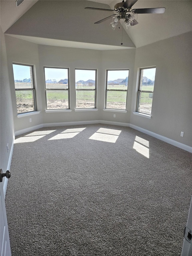 unfurnished room featuring carpet floors, vaulted ceiling, plenty of natural light, and ceiling fan