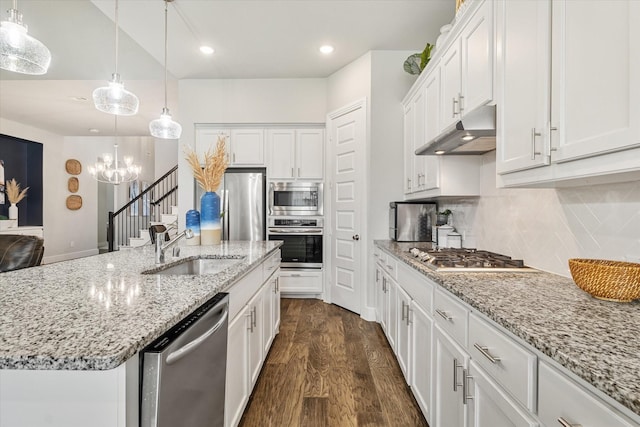 kitchen featuring dark wood-type flooring, under cabinet range hood, stainless steel appliances, white cabinetry, and a sink