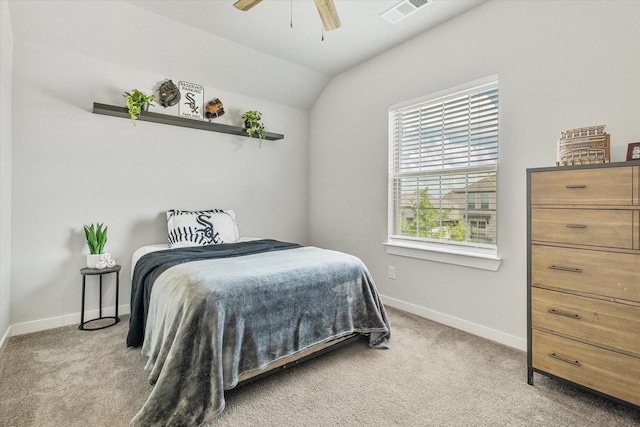 bedroom featuring lofted ceiling, baseboards, visible vents, and light carpet