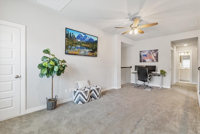 carpeted office space featuring baseboards, visible vents, and ceiling fan