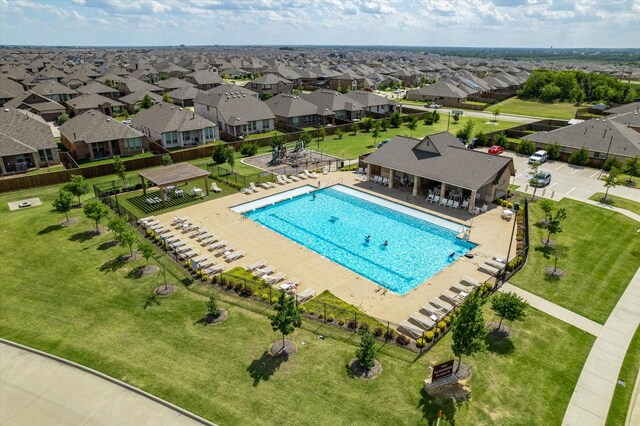 community pool featuring a patio area, a residential view, and fence