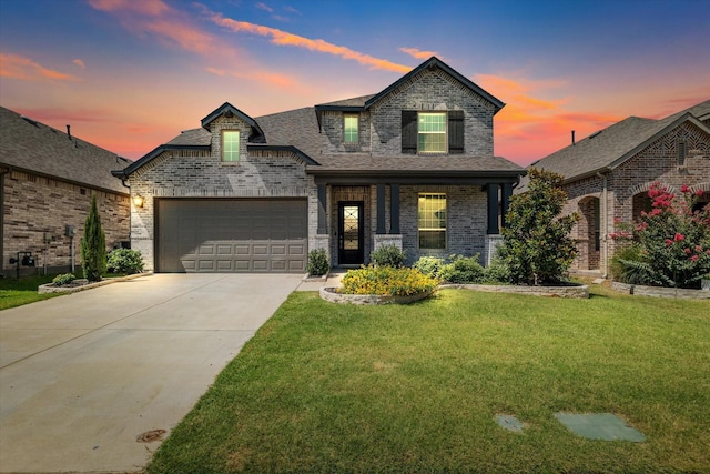 view of front of home featuring a garage, driveway, brick siding, and a lawn