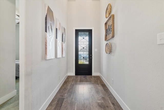 doorway featuring baseboards and dark wood-style flooring