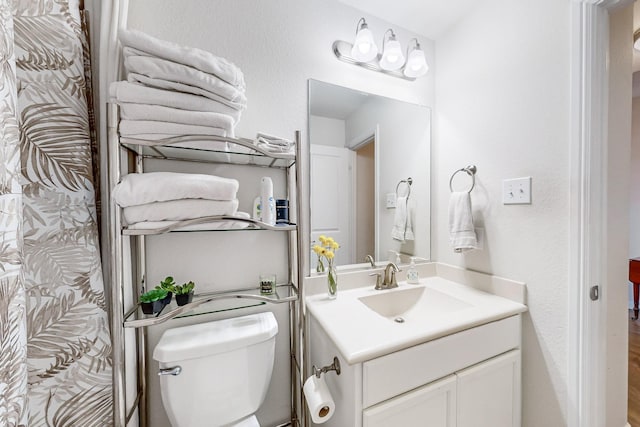 full bathroom with toilet, wood finished floors, and vanity