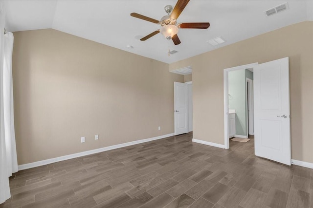 unfurnished bedroom featuring connected bathroom, vaulted ceiling, visible vents, wood finished floors, and baseboards