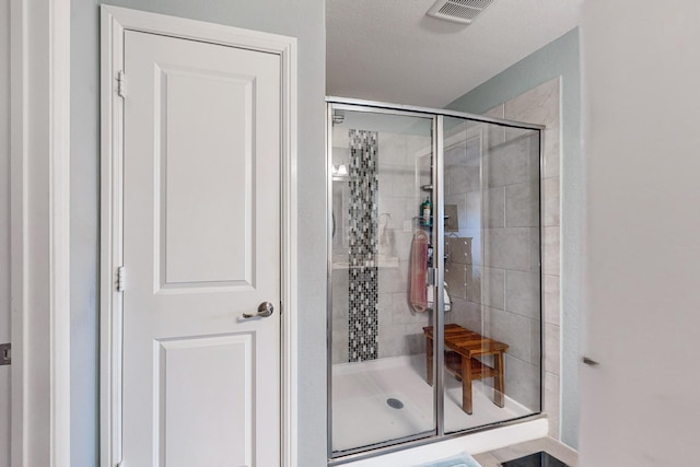 full bath with visible vents and a shower stall