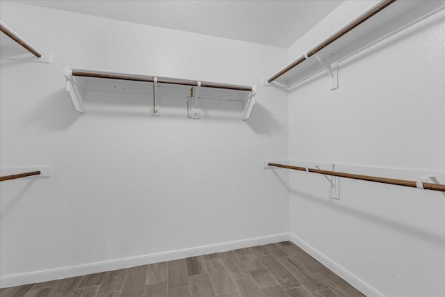 walk in closet with wood finished floors