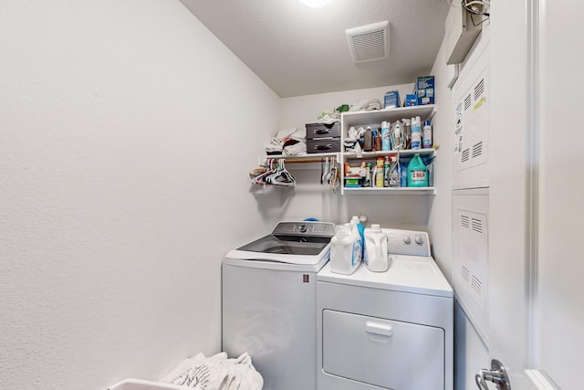 washroom with visible vents, separate washer and dryer, and laundry area