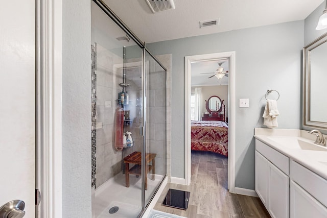 bathroom featuring ceiling fan, vanity, wood-type flooring, and an enclosed shower