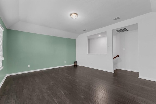 unfurnished room featuring visible vents, wood finished floors, and vaulted ceiling