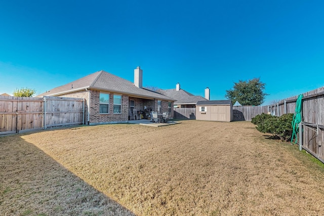 back of house with a patio, a storage shed, and a lawn