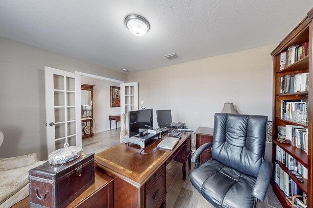 office space featuring french doors and hardwood / wood-style floors