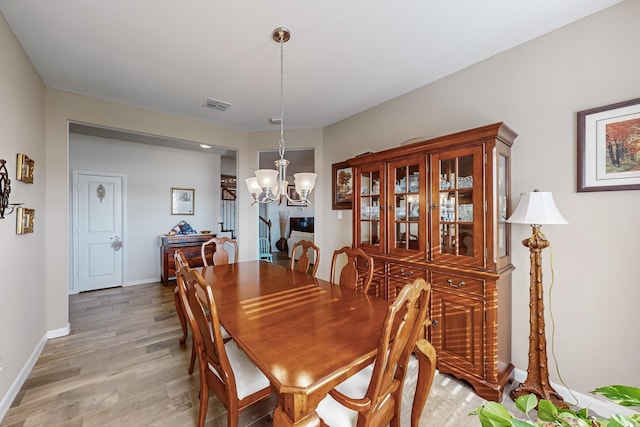 dining area featuring hardwood / wood-style floors and a notable chandelier