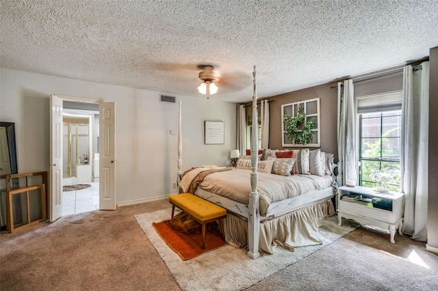 carpeted bedroom featuring ceiling fan, connected bathroom, and a textured ceiling