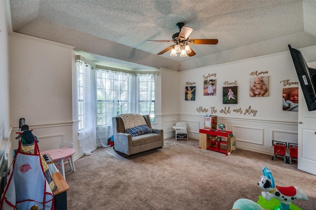 game room featuring light carpet, ceiling fan, a raised ceiling, and a textured ceiling