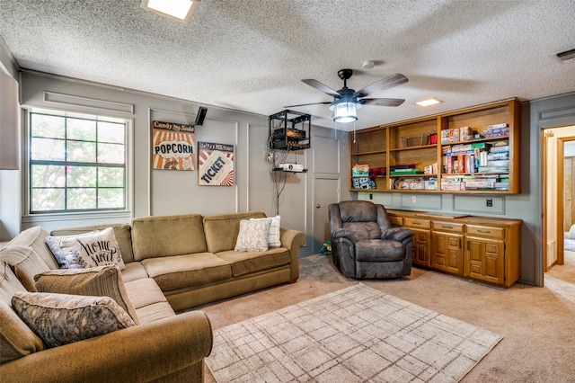 living room featuring ceiling fan, light carpet, and a textured ceiling