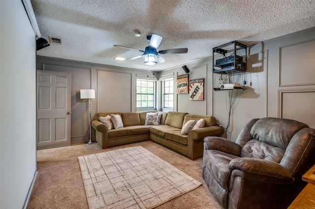 living room featuring ceiling fan, light colored carpet, and a textured ceiling