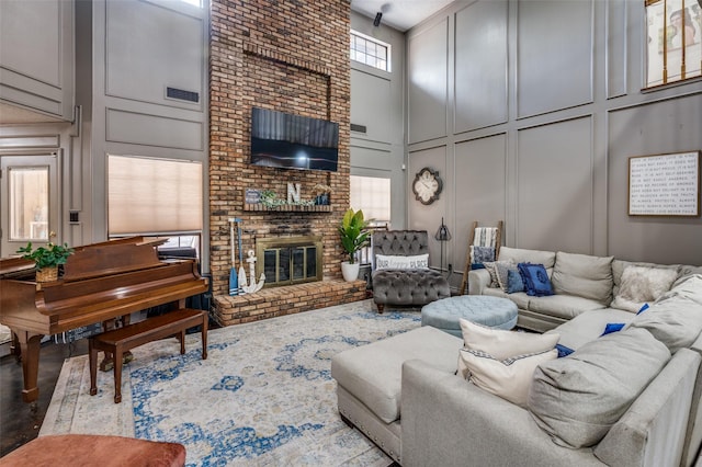 living room with a fireplace and a high ceiling